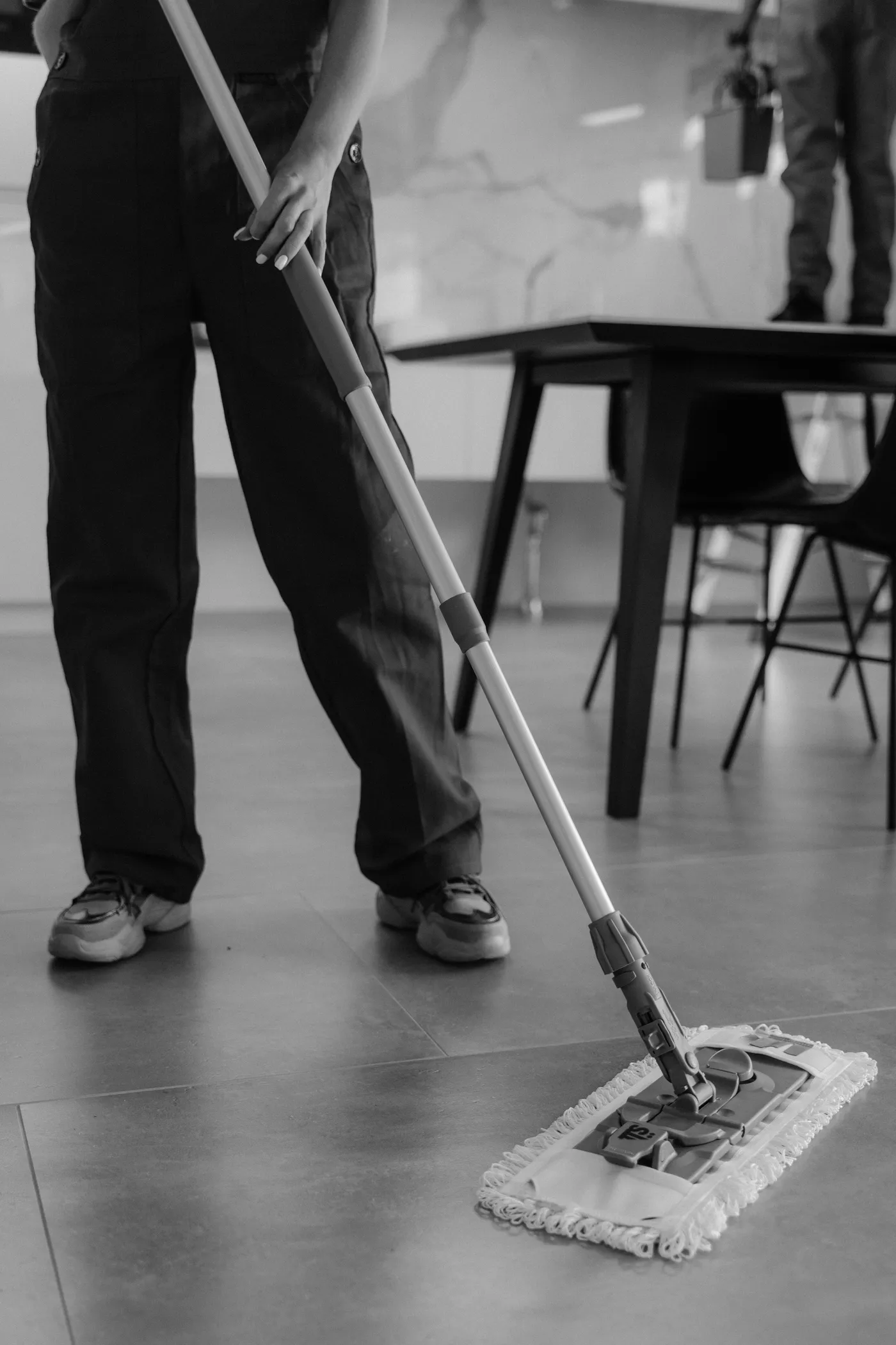 A cleaner mopping a modern kitchen floor
